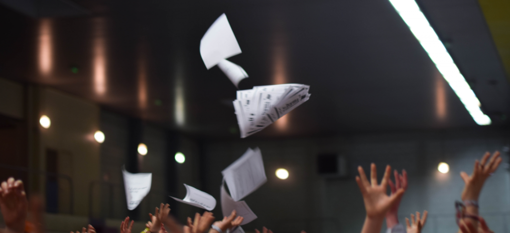 Image prise lors du Festival Expresso organisé par Jets d'encre, elle représente des mains et des qui lancent des journaux. 